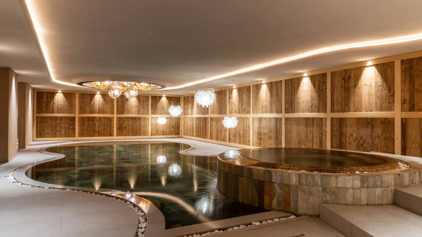 Ein luxuriöser Innenpool mit Holzwänden und moderner Beleuchtung.