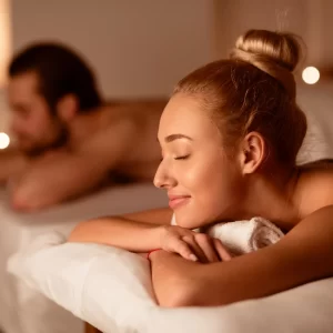 Due persone rilassate godono di un trattamento benessere su lettini da massaggio.